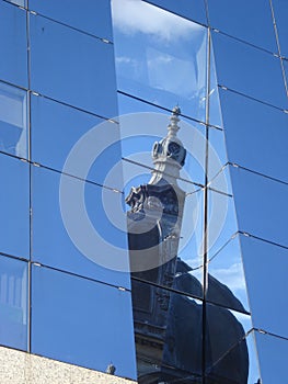 Dome of old style historical building, reflected on glass wall of modern building